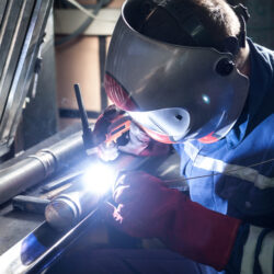 Closeup of man wearing mask welding in a workshop Backing Gas in Austenitic and Duplex Stainless Steel Welds